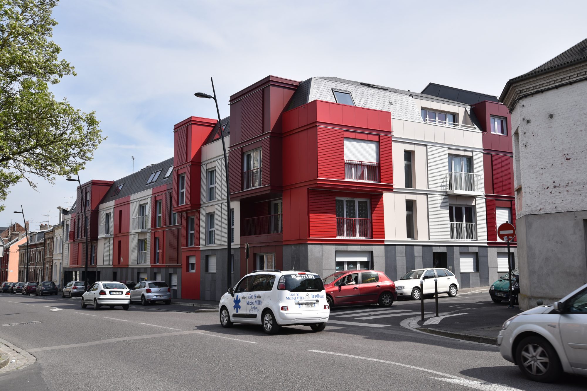 Résidence le Carrousel à Amiens vue depuis le carrefour, façades en bandes rouges, bordeaux et claires