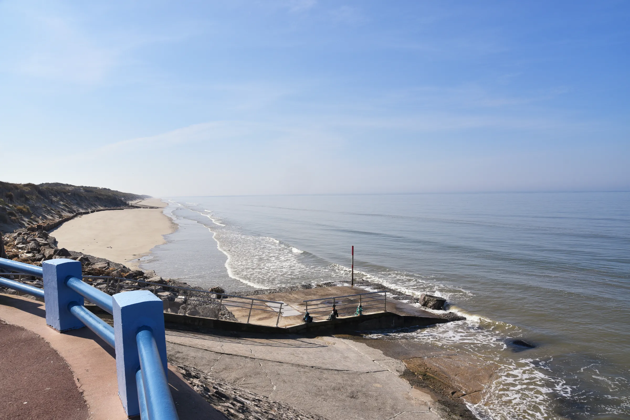 Plage de Quend-Plage vue depuis le front de mer, sable, vagues et garde-corps bleu de la promenade