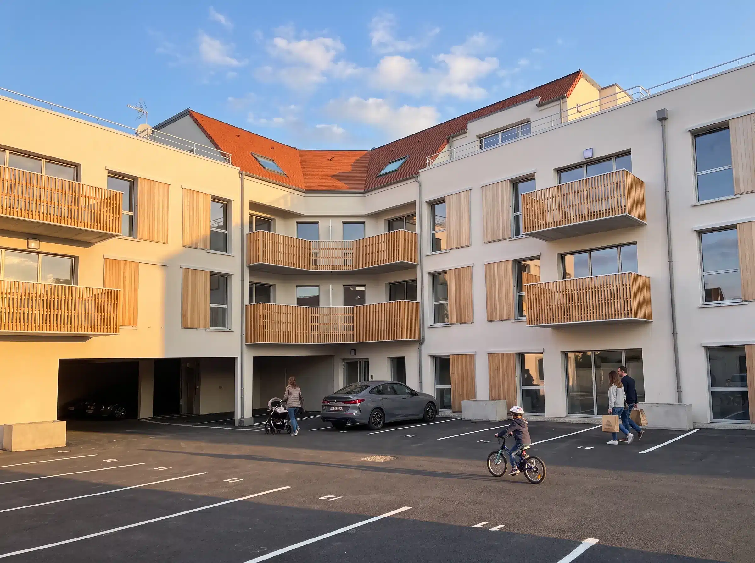 Façades sur cour de la résidence du Bois Flotté à Quend-Plage, enduit clair, balcons en bois et toiture en tuiles rouges