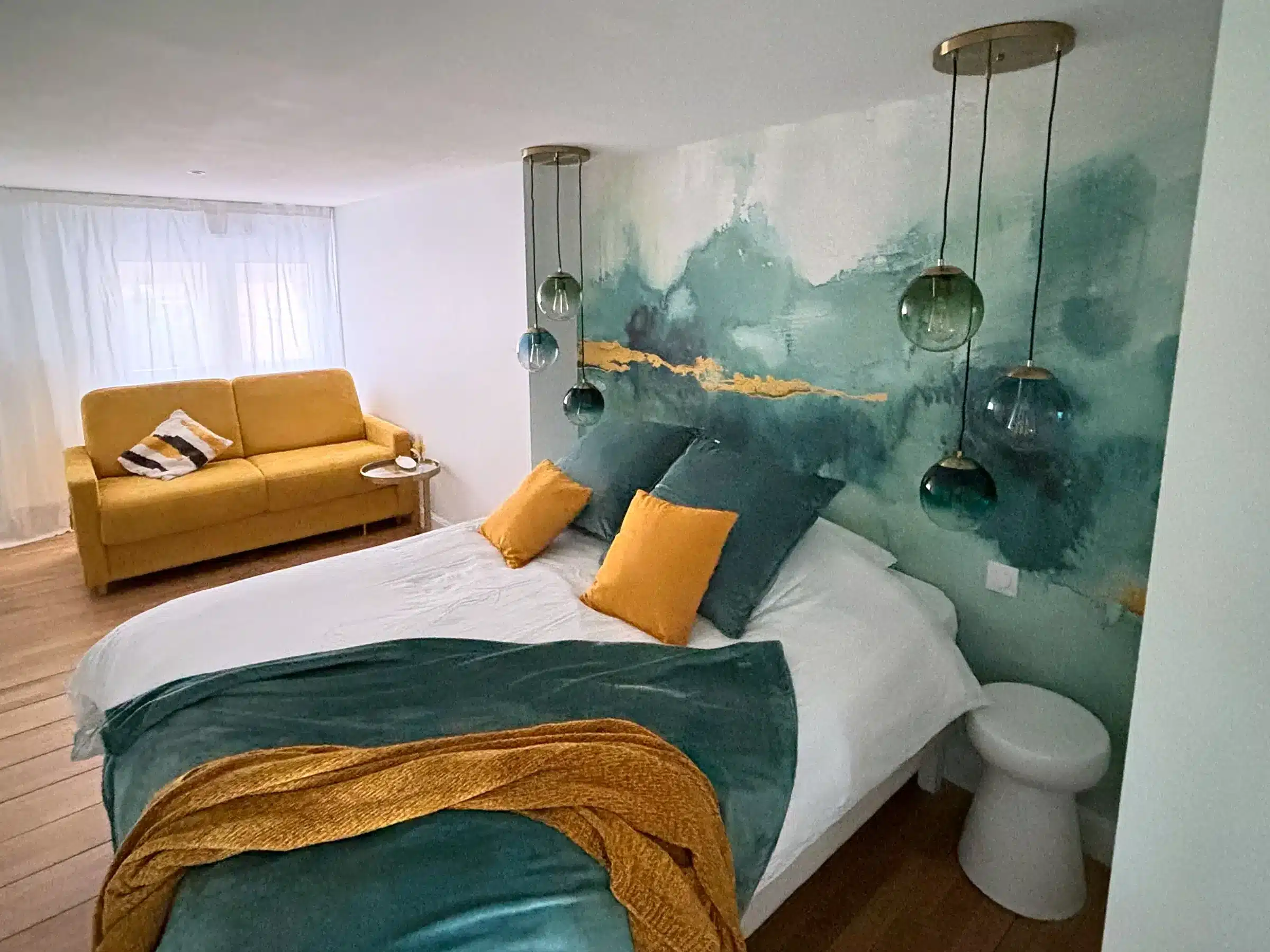 Chambre avec fresque aquarelle verte et suspensions en verre soufflé, appartement de la Tour A d'Altéia