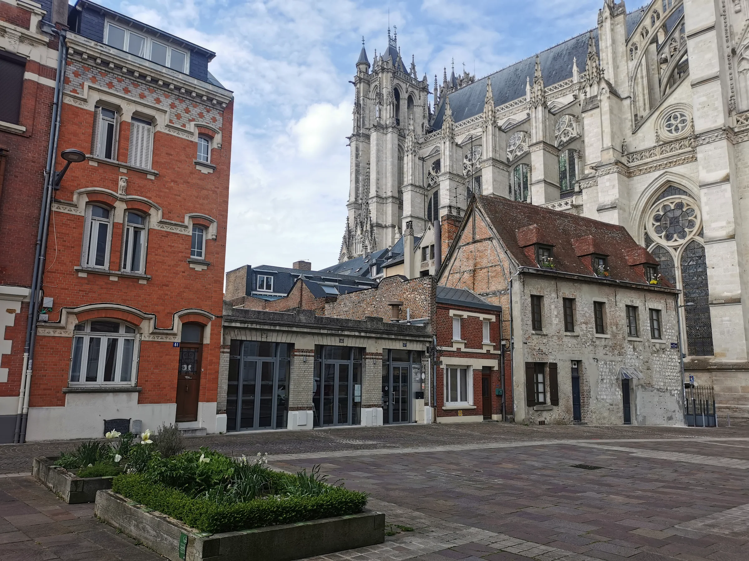 Rue Robert de Luzarches à Amiens avant travaux : rez-de-chaussée commercial et maison de ville au pied de la cathédrale