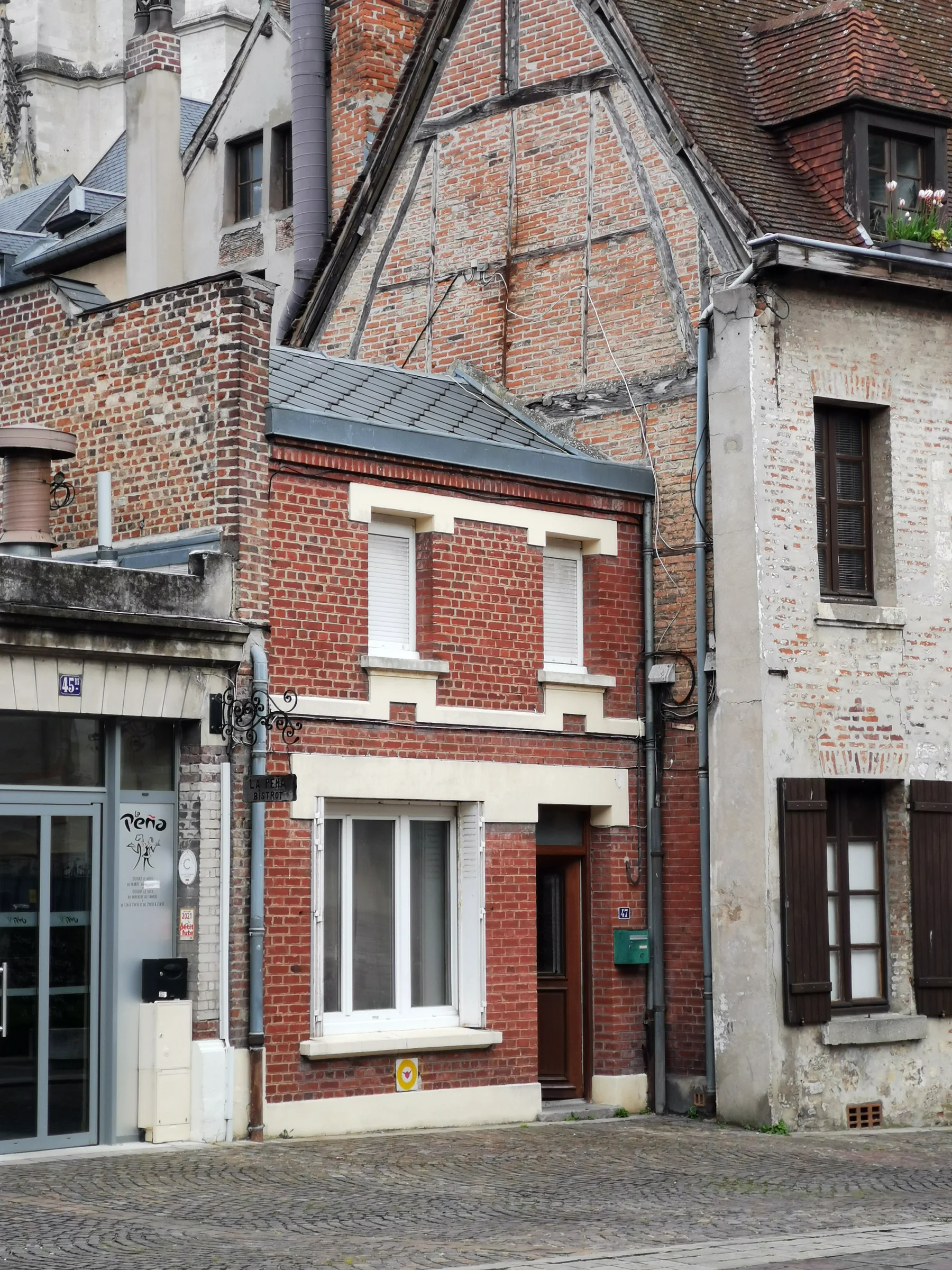 Petite maison de ville en brique rouge, existante, conservée et surélevée pour former l'entrée de la Maison V